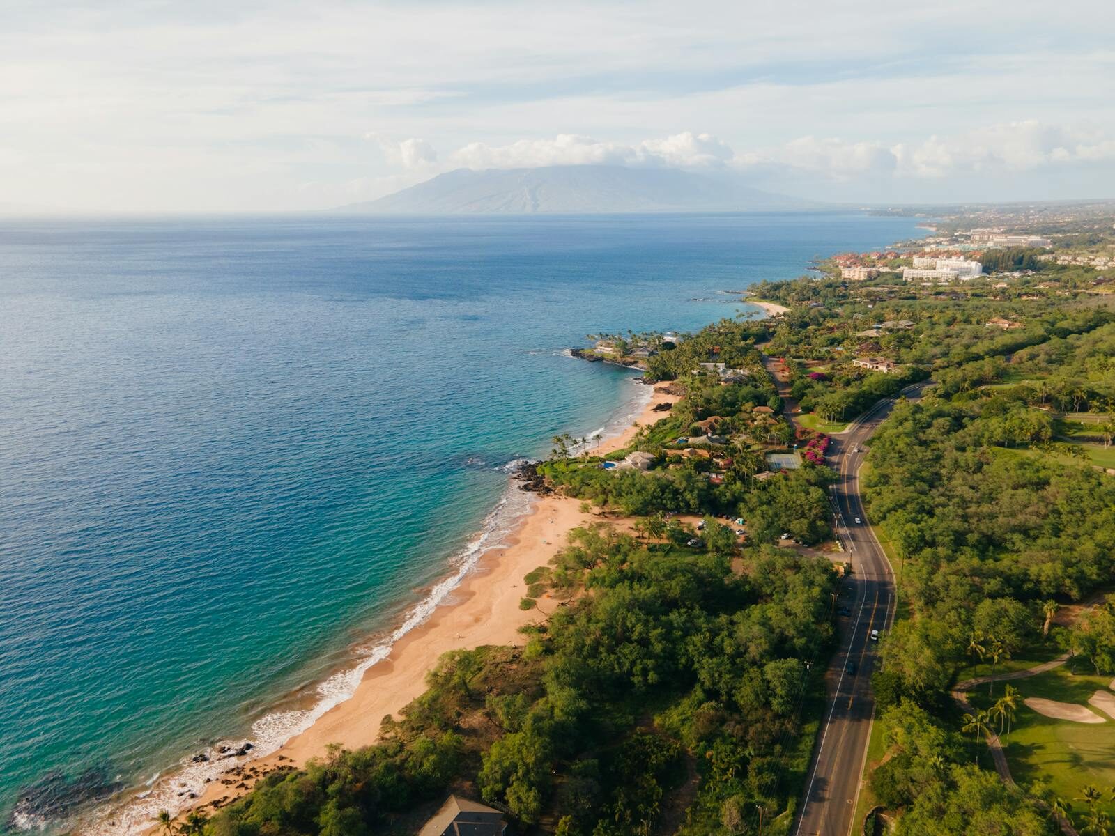 Explore the stunning coastline of Kihei, Hawaii from above, showcasing ocean views and lush greenery.