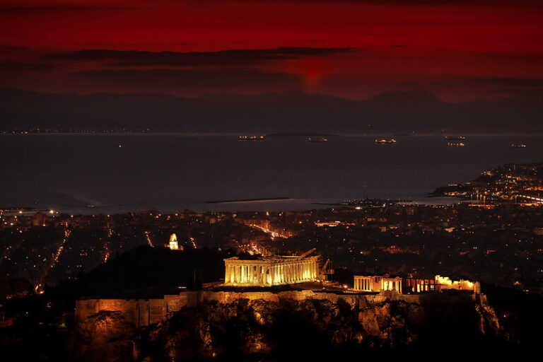 The Parthenon atop the Acropolis lit at dusk in Athens, Greece