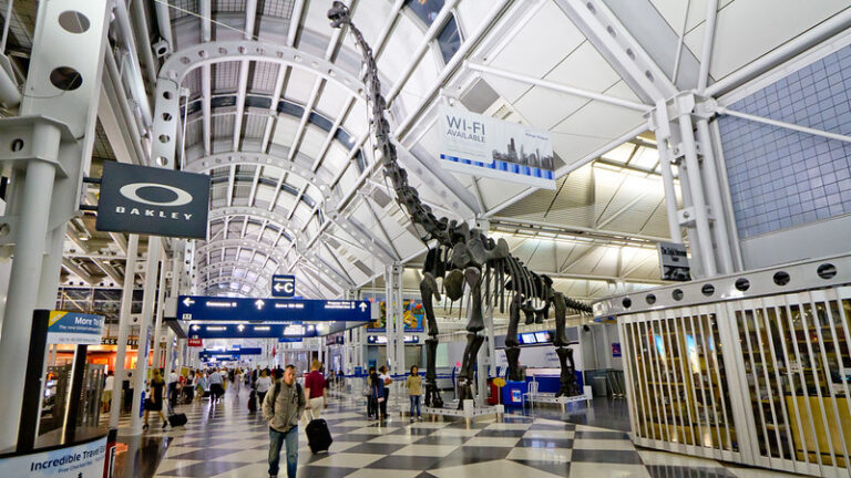 Travelers walking through a busy airport departure terminal