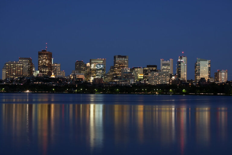 The Boston skyline rising over the harbor at dusk