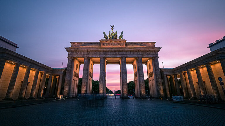 The Brandenburg Gate in central Berlin against a blue sky