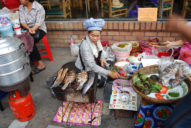 Street food stall at Chiang Mai night market with grilled fish and local dishes
