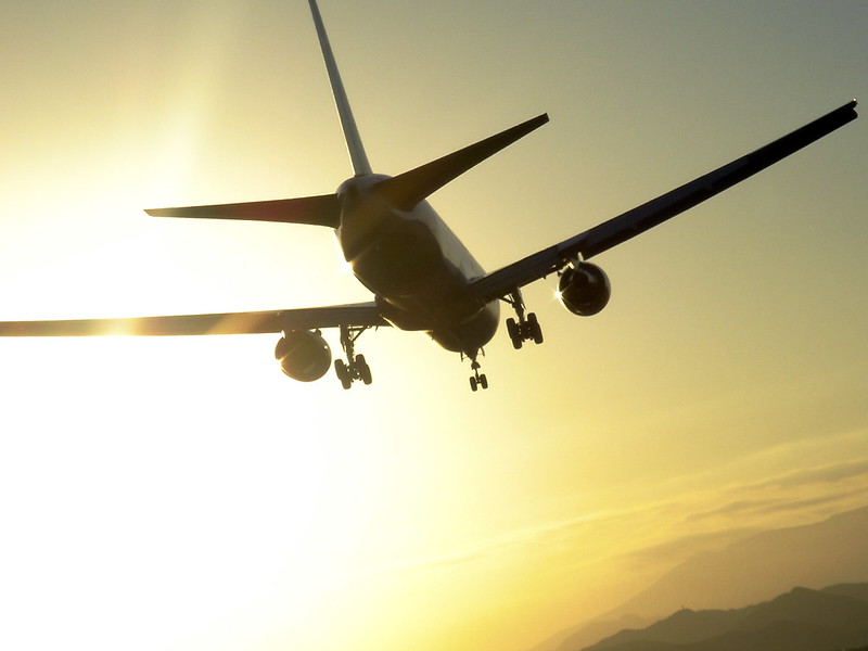 Airplane flying against a colorful sunset sky