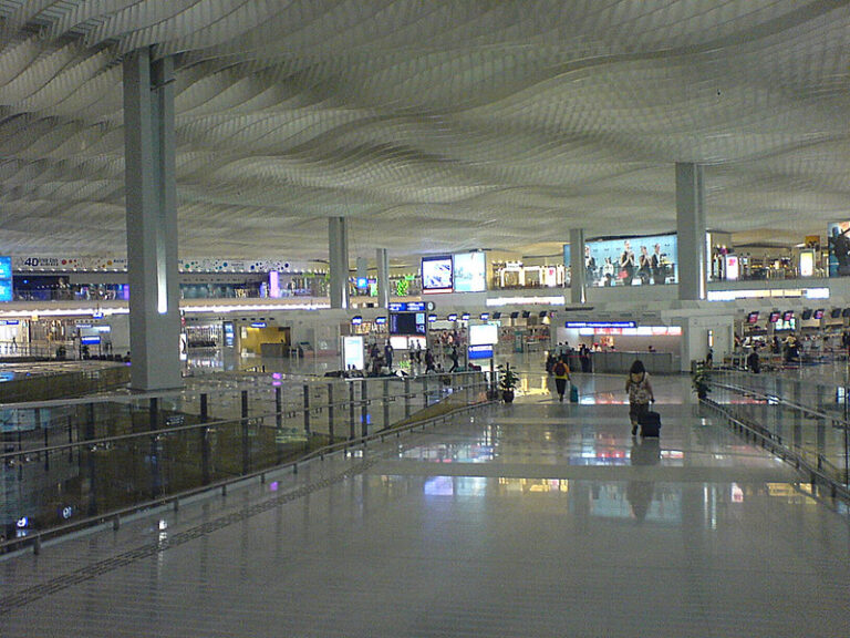 Travelers waiting in an airport departure terminal before an international flight