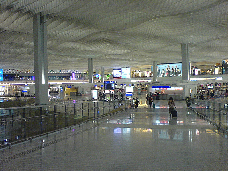Travelers waiting in an airport departure terminal before an international flight