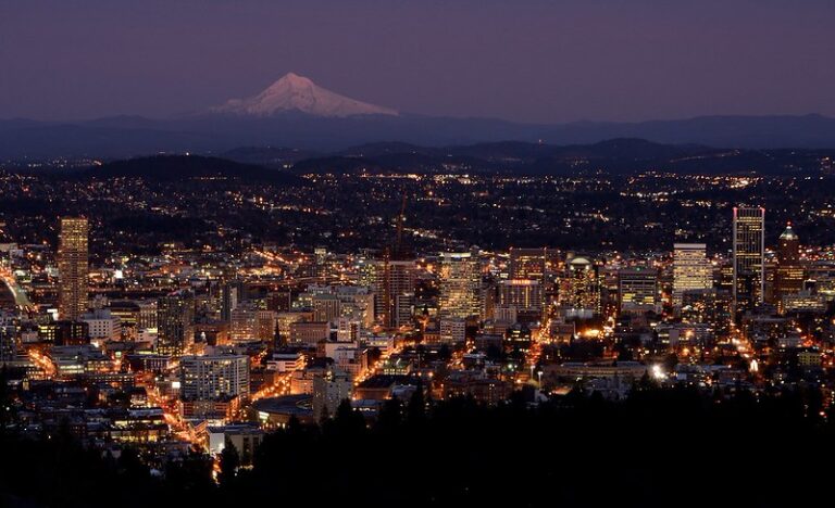 Downtown Portland Oregon skyline glowing at dusk along the Willamette River