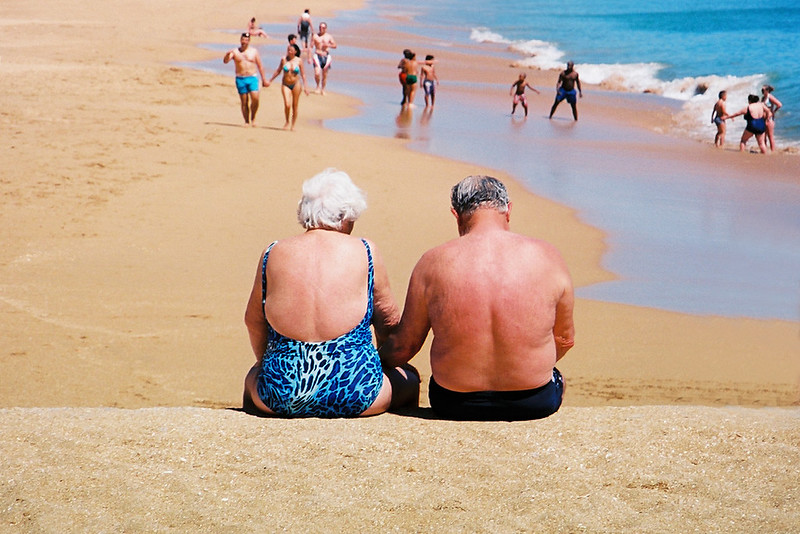 Older couple enjoying a beach vacation, travel insurance for seniors