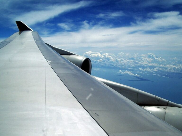 View of an airplane wing above the clouds from a window seat