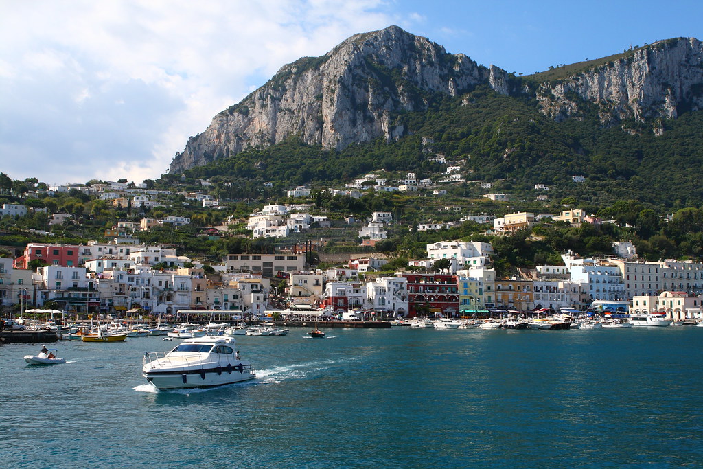 Colorful Marina Grande waterfront and boats below the green hills of Capri