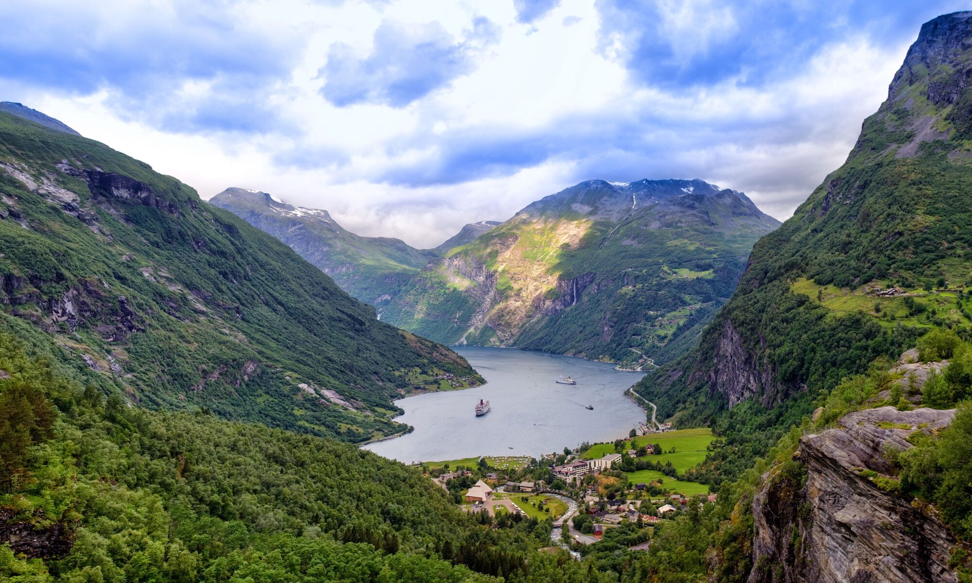 Waterfalls and steep green cliffs above the Geirangerfjord in summer Norway