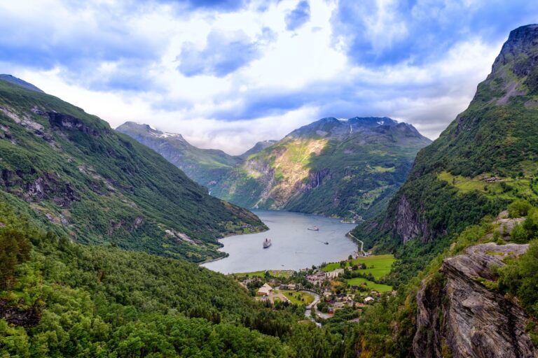 Waterfalls and steep green cliffs above the Geirangerfjord in summer Norway