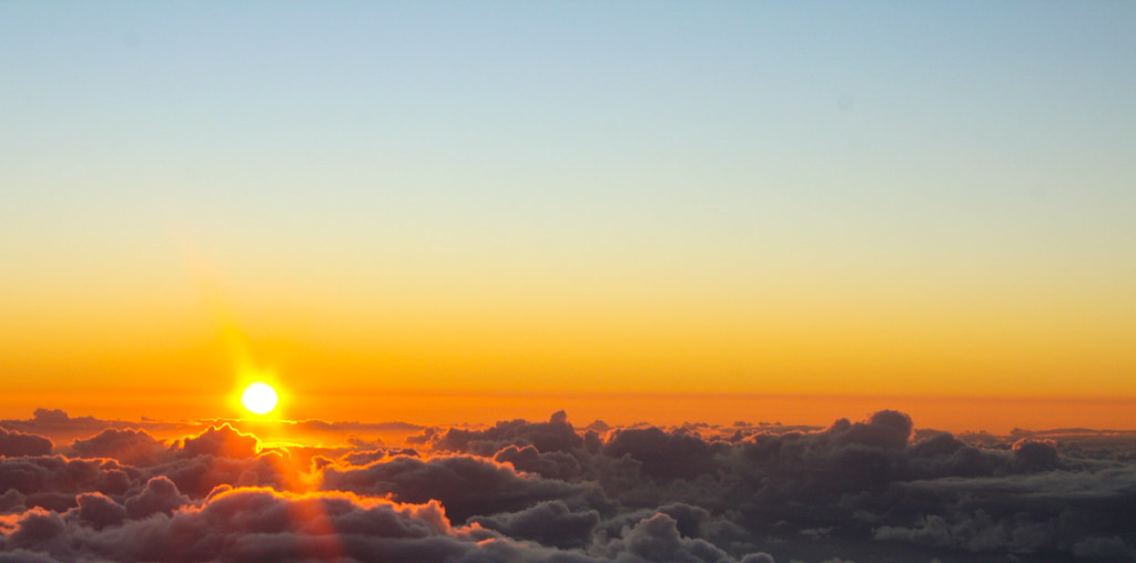 Golden sunrise above a sea of clouds from the Haleakala summit on Maui