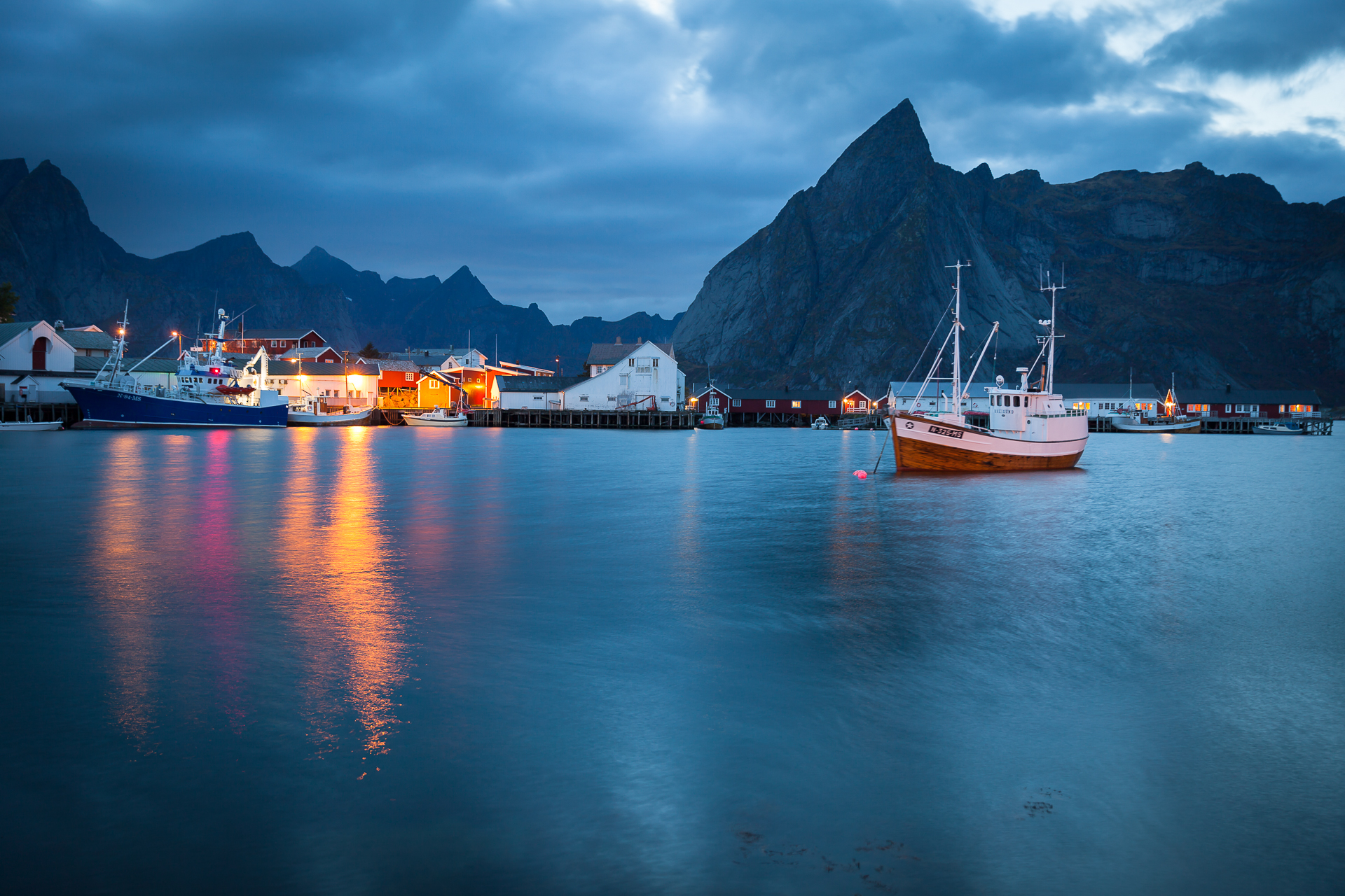 Traditional red fishing cabins at Hamnoy framed by dramatic mountains in Lofoten