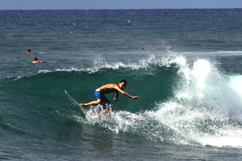 Surfer riding a wave at Sunset Beach on the Oahu North Shore in Hawaii