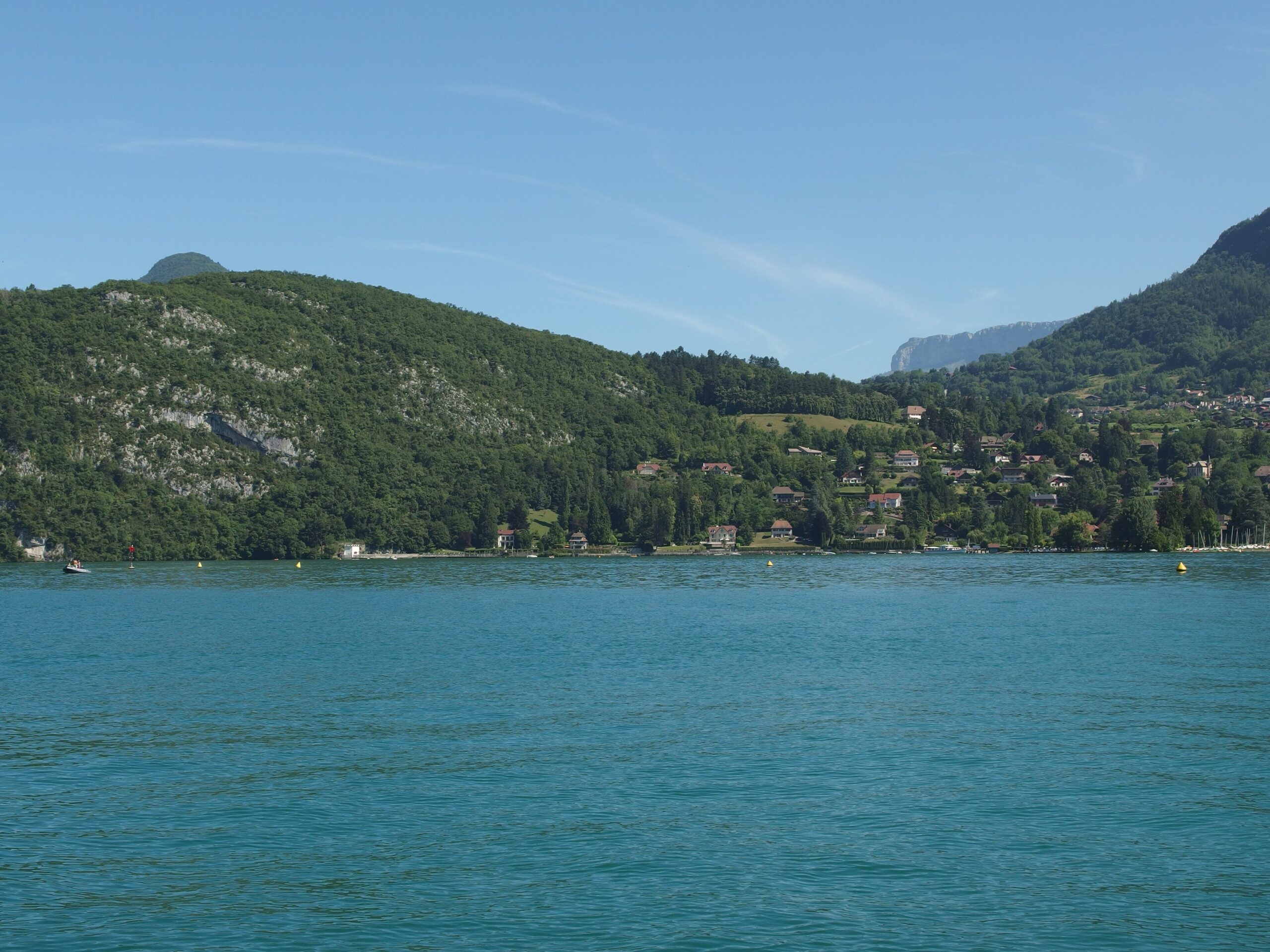 A boat on the turquoise water of Lake Annecy in the French Alps