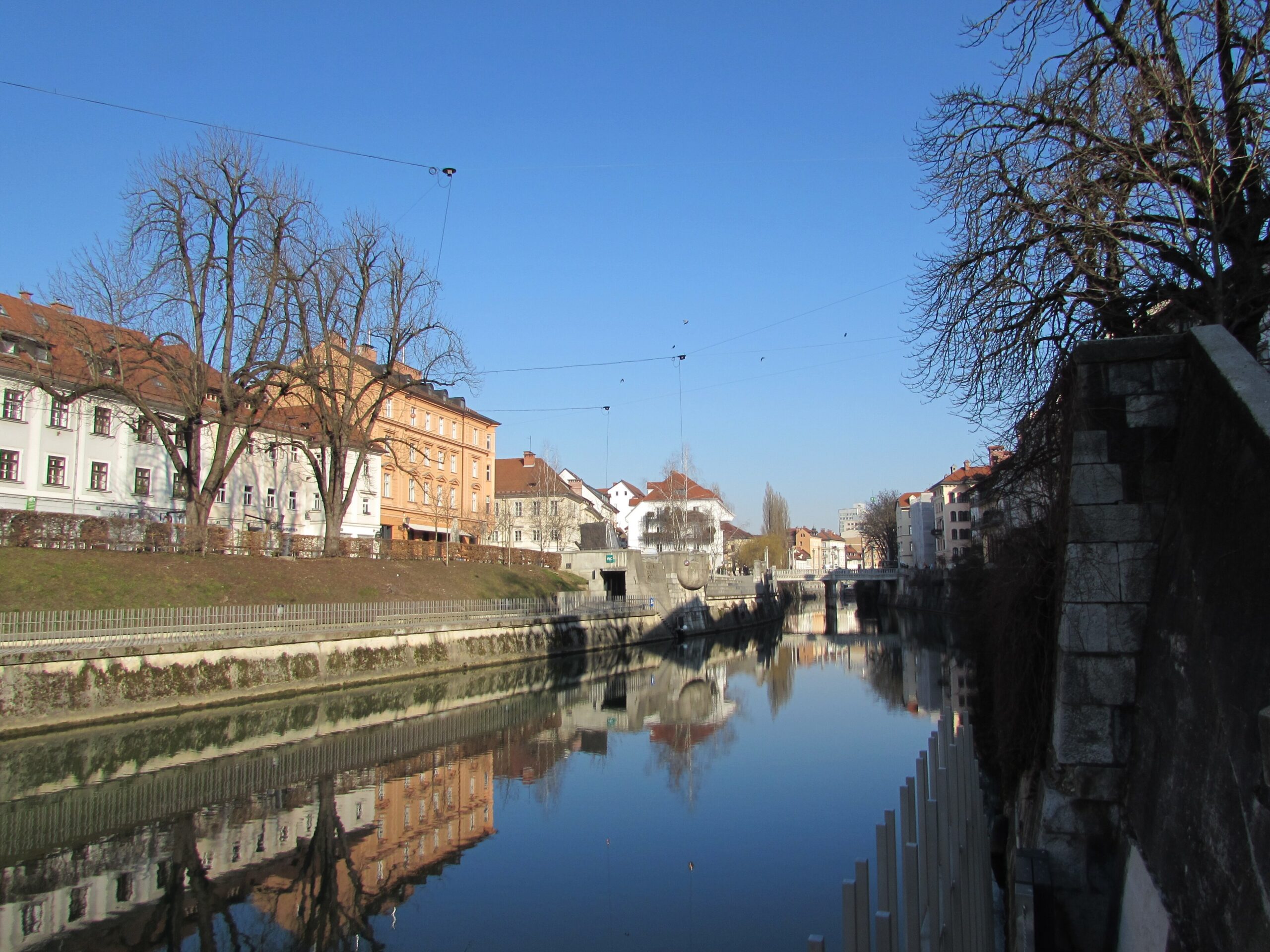 Pastel buildings reflected in the Ljubljanica river in central Ljubljana