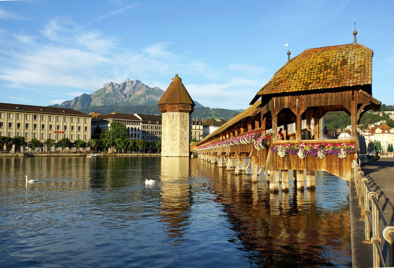 The wooden Chapel Bridge and Water Tower in Lucerne with Mount Pilatus behind