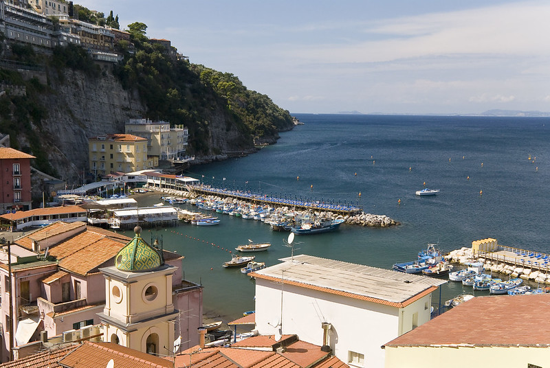 Colorful fishing boats and a church dome at Marina Grande in Sorrento, Italy