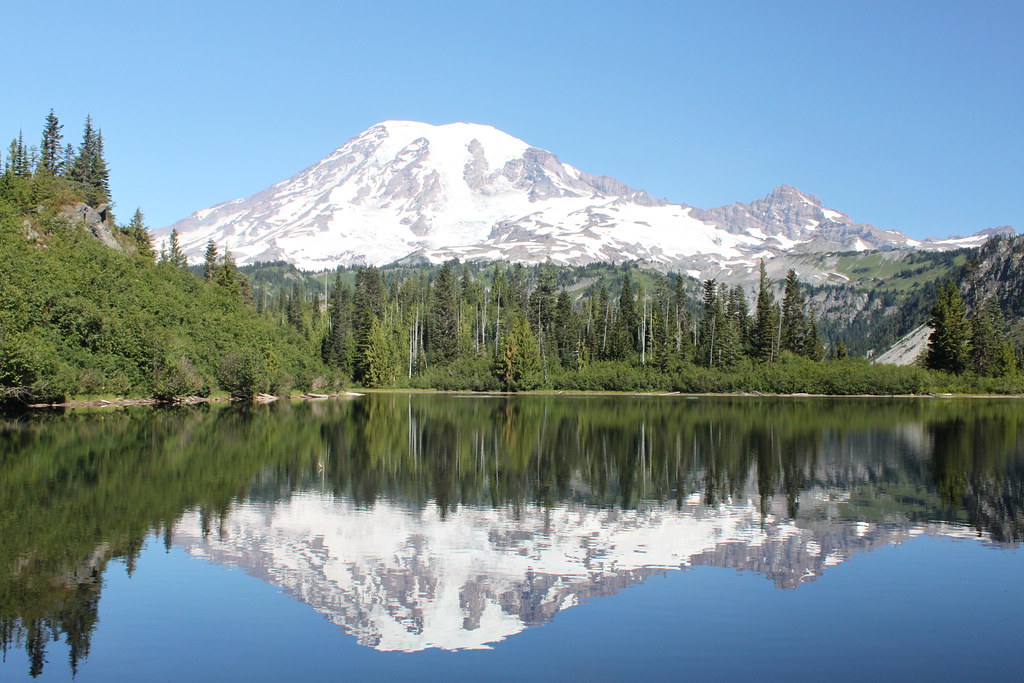 Mount Rainier mirrored in the still water of a subalpine lake