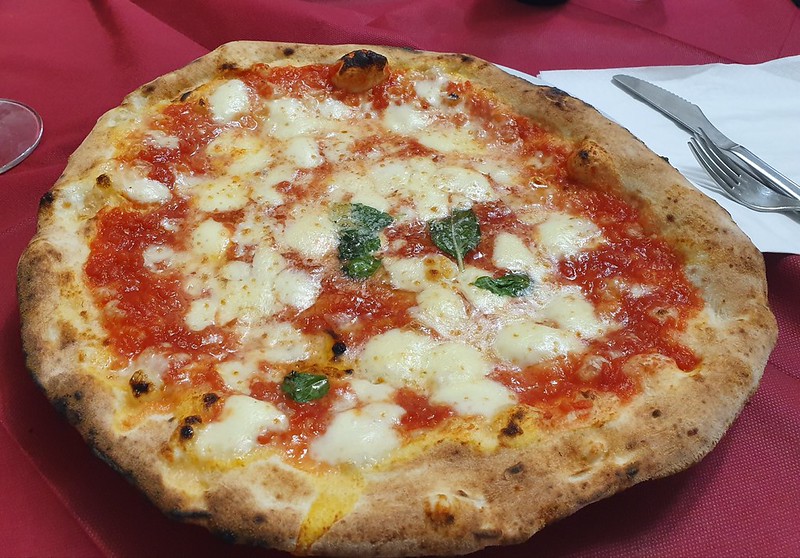 Wood-fired pizza Margherita on a plate in Naples, the birthplace of pizza