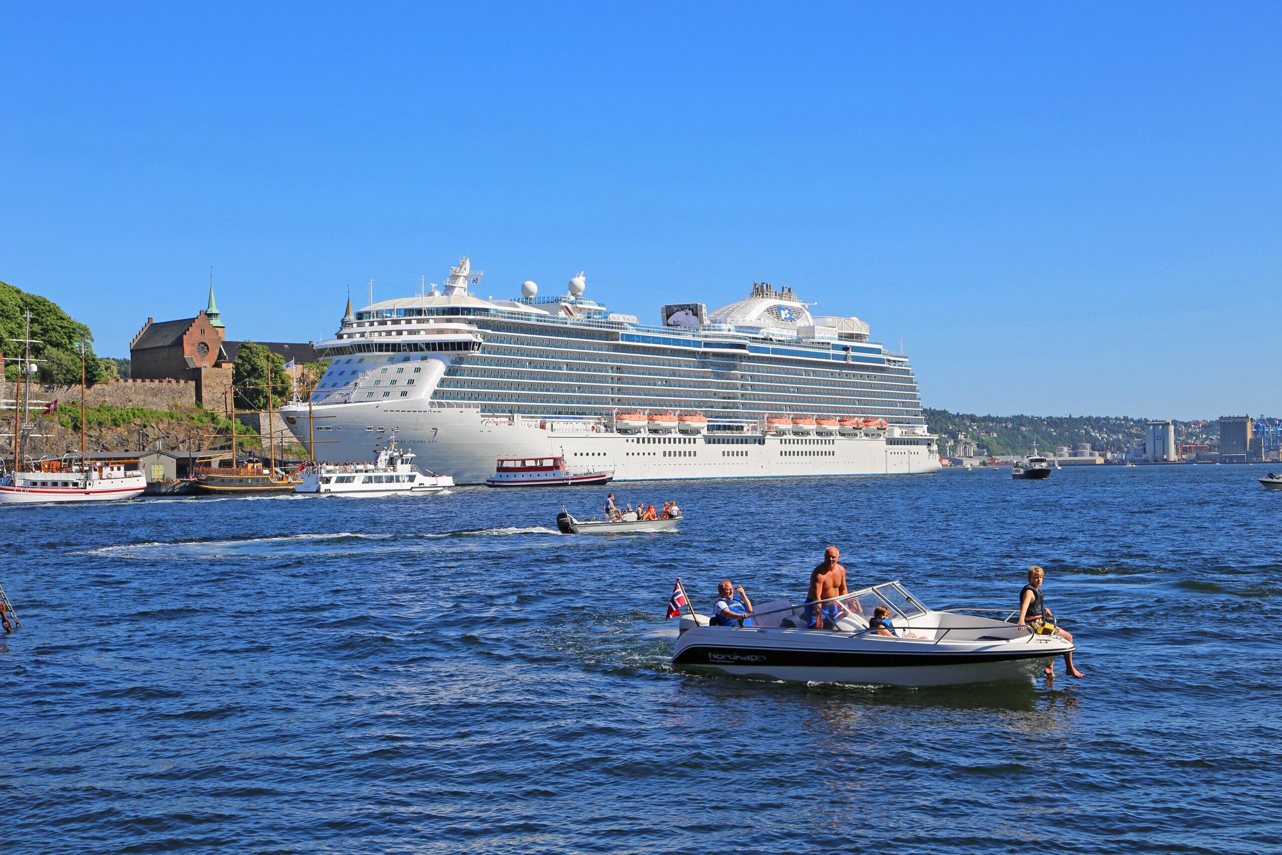 Boats in Oslo harbour below the stone walls of Akershus Fortress