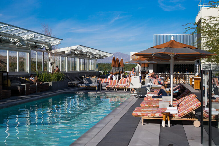 Palm-lined hotel pool with the San Jacinto Mountains behind in Palm Springs California