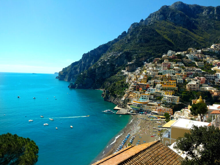 Turquoise sea and pastel cliffside houses of Positano on the Amalfi Coast