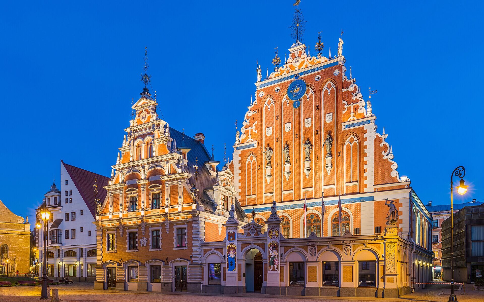 The ornate House of the Blackheads lit up at dusk in Riga old town Latvia