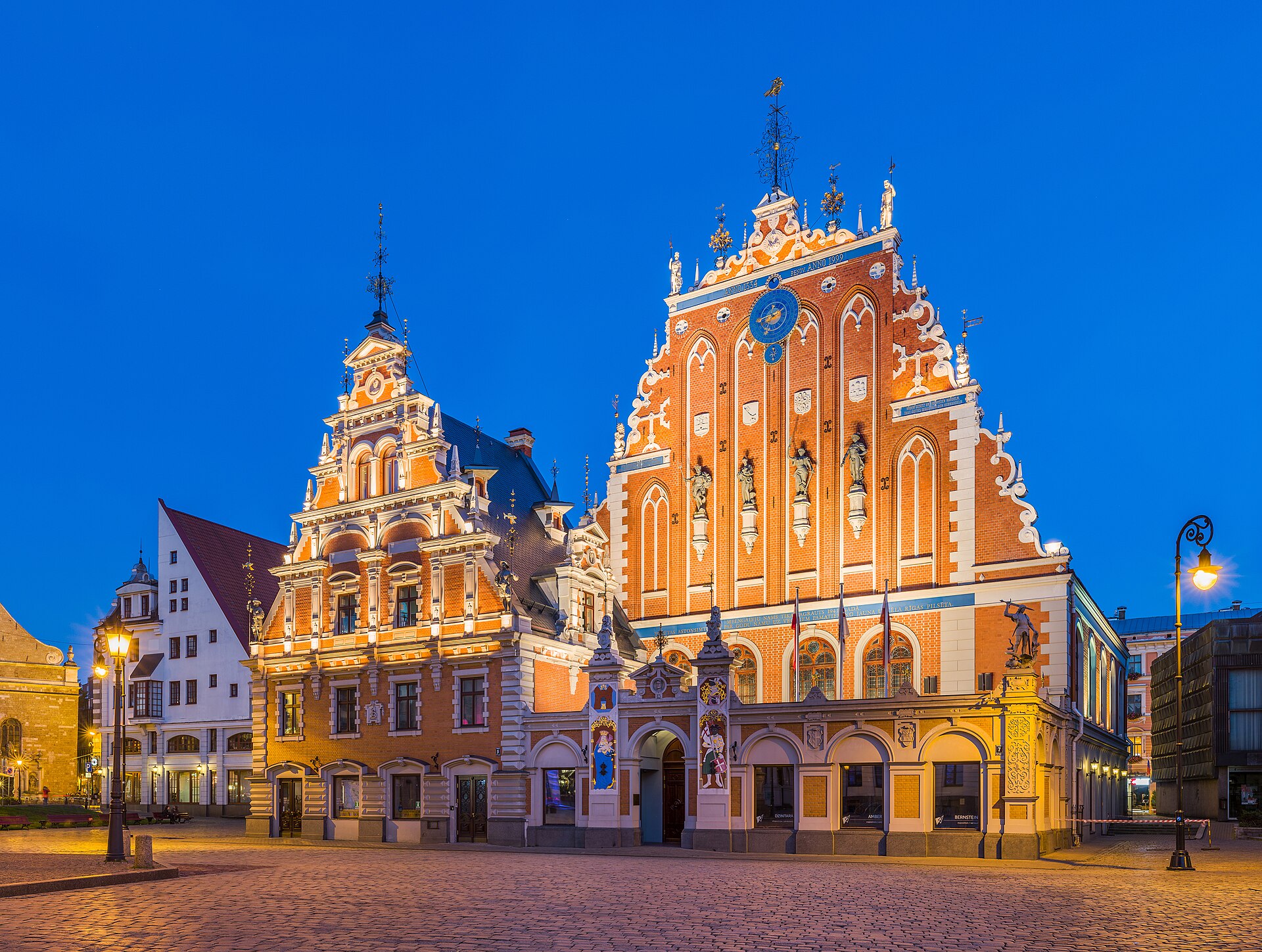 The ornate House of the Blackheads lit up at dusk in Riga old town Latvia