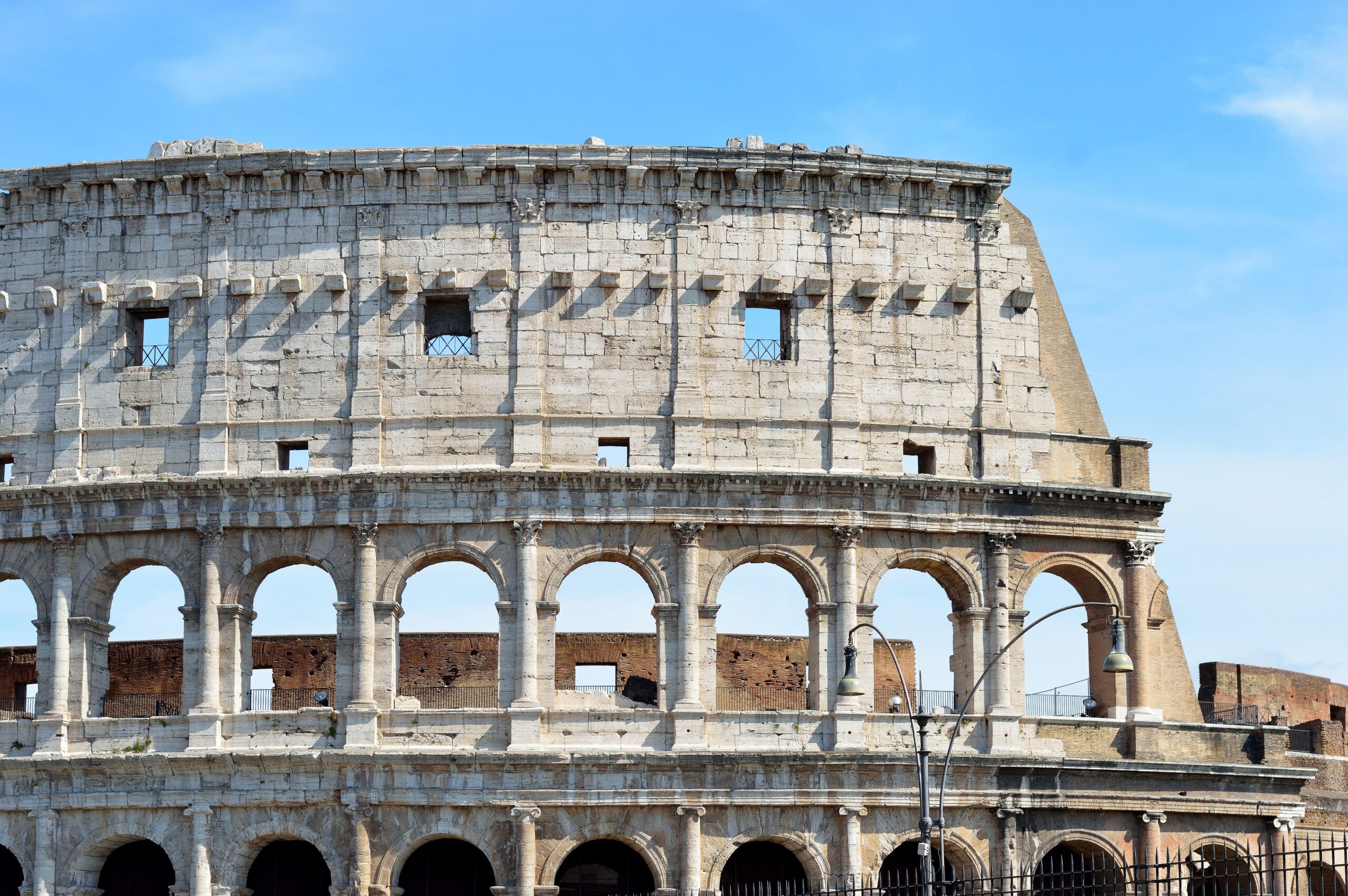 The ancient Roman Colosseum under a blue sky in Rome, Italy