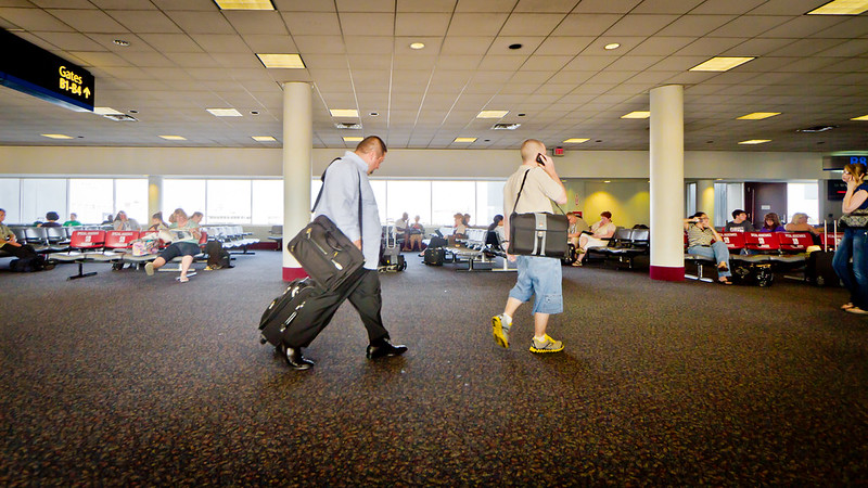Traveler walking through an airport terminal with a rolling bag