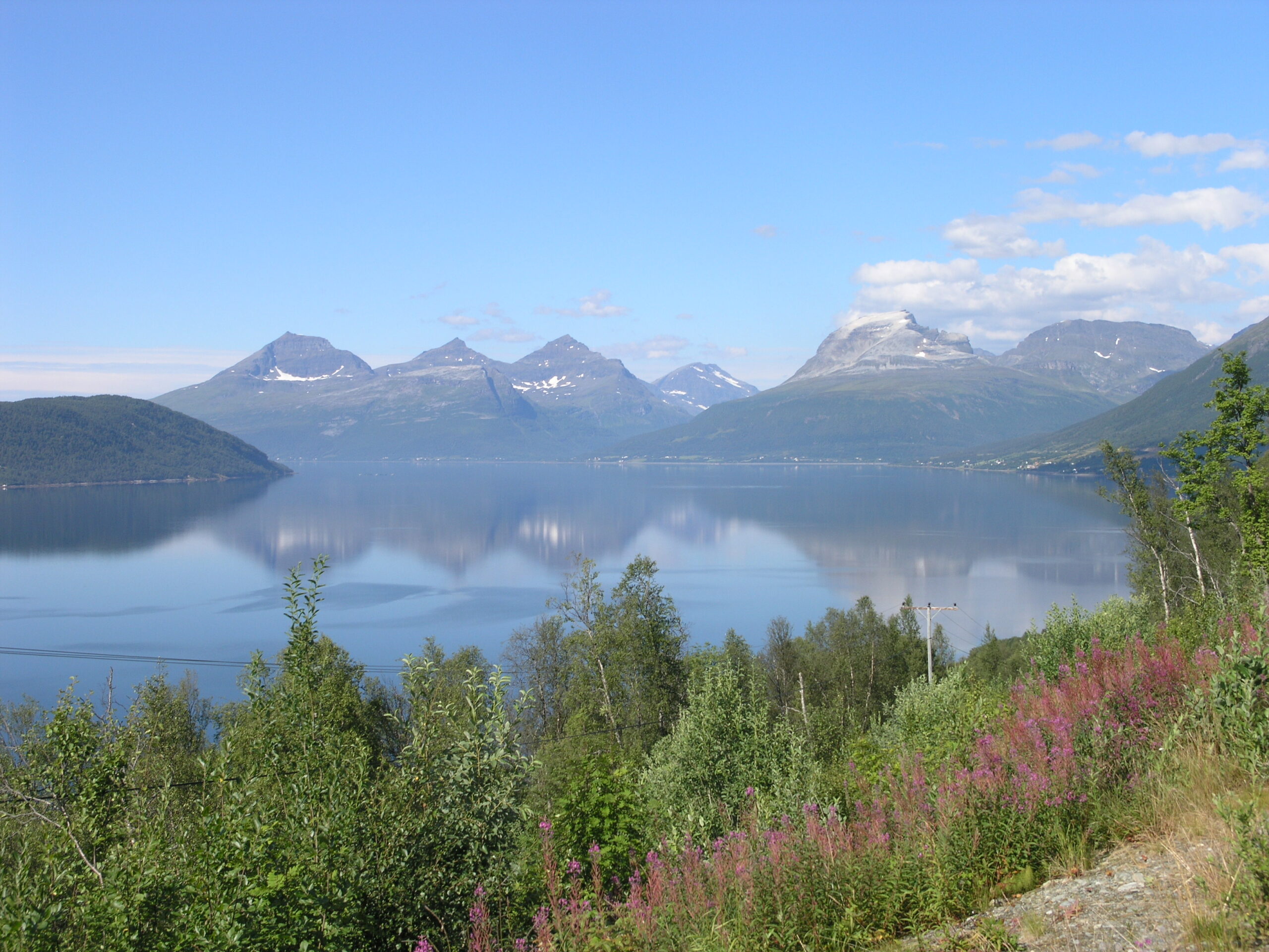 A calm fjord ringed by snow-streaked mountains near Tromso, Norway
