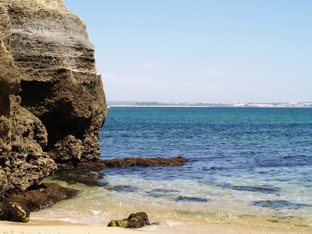 Golden limestone cliffs and turquoise water on a beach near Lagos in the Algarve