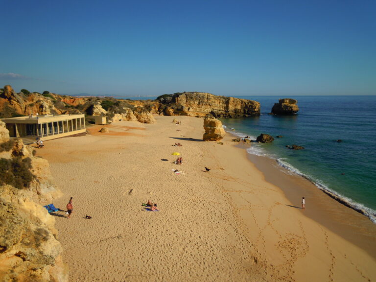 Golden limestone cliffs above a sandy cove on the Algarve coast in Portugal
