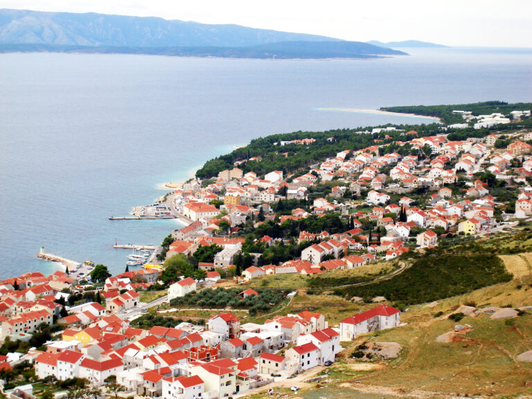 Stone waterfront town of Bol on Brac island with the Adriatic Sea and hills behind