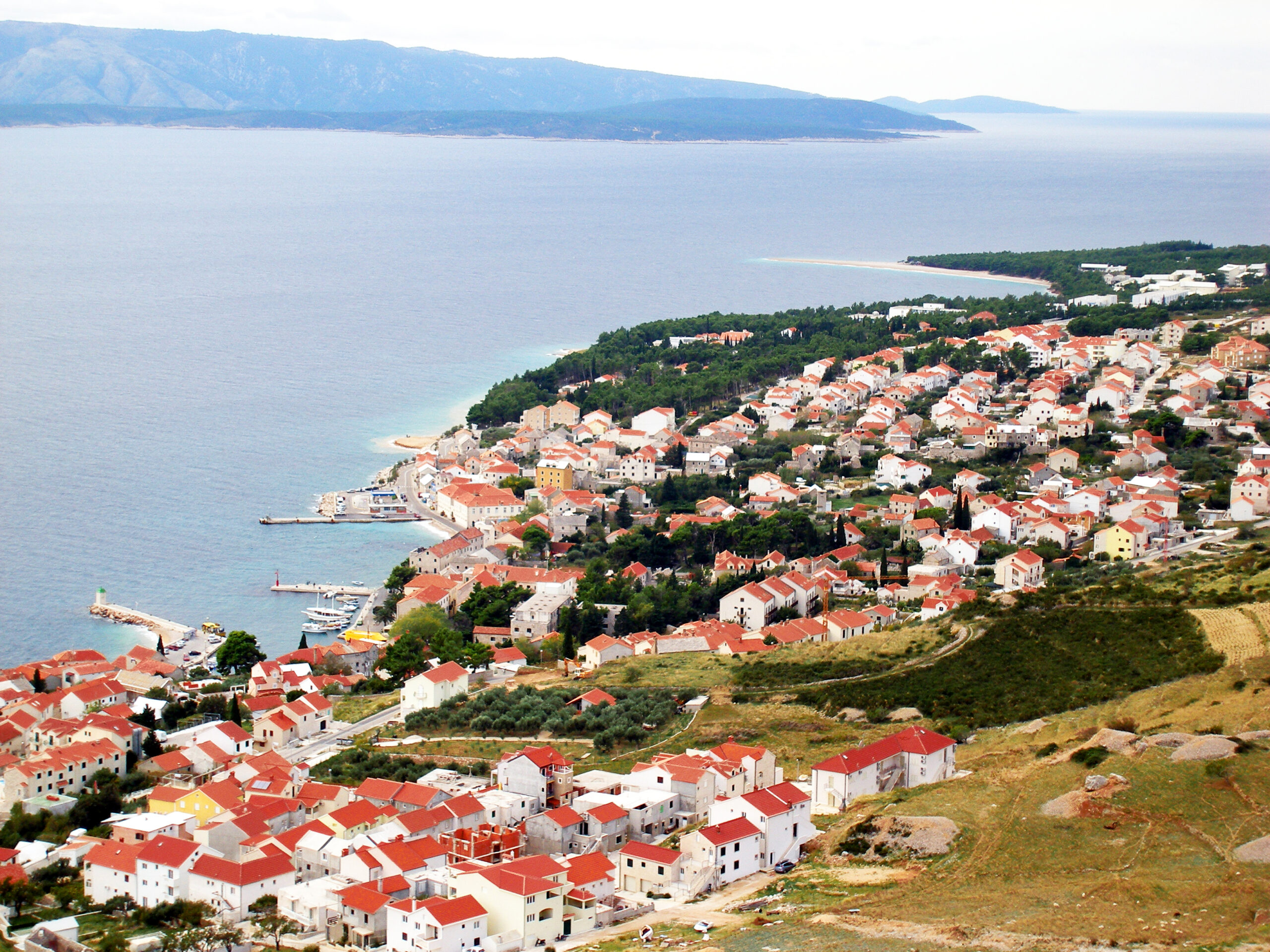 Stone waterfront town of Bol on Brac island with the Adriatic Sea and hills behind
