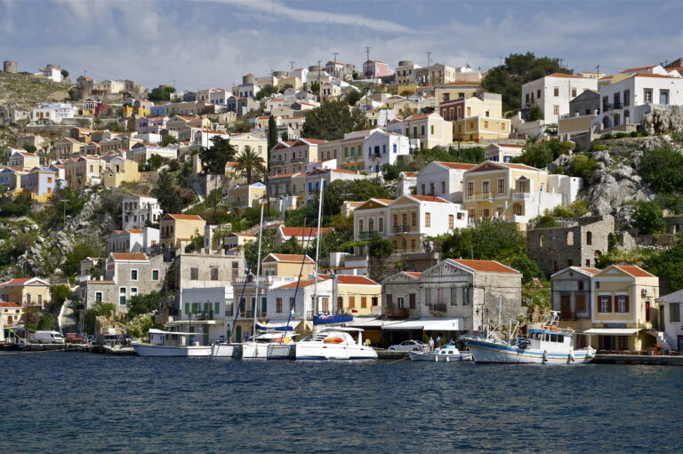 Colourful stacked houses rising above a Greek island harbour