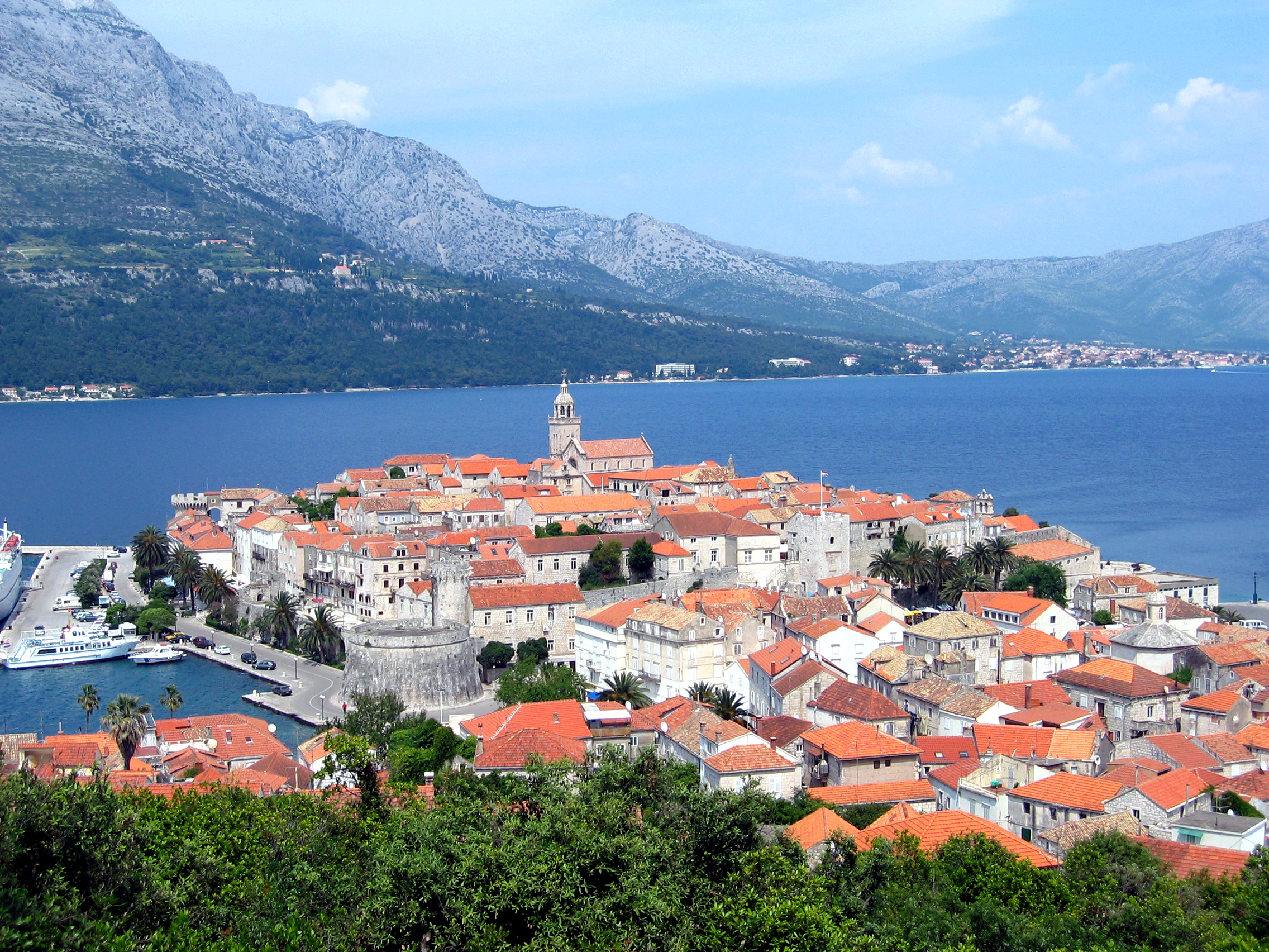 Stone houses and the cathedral bell tower of Korcula Town rising above the harbour