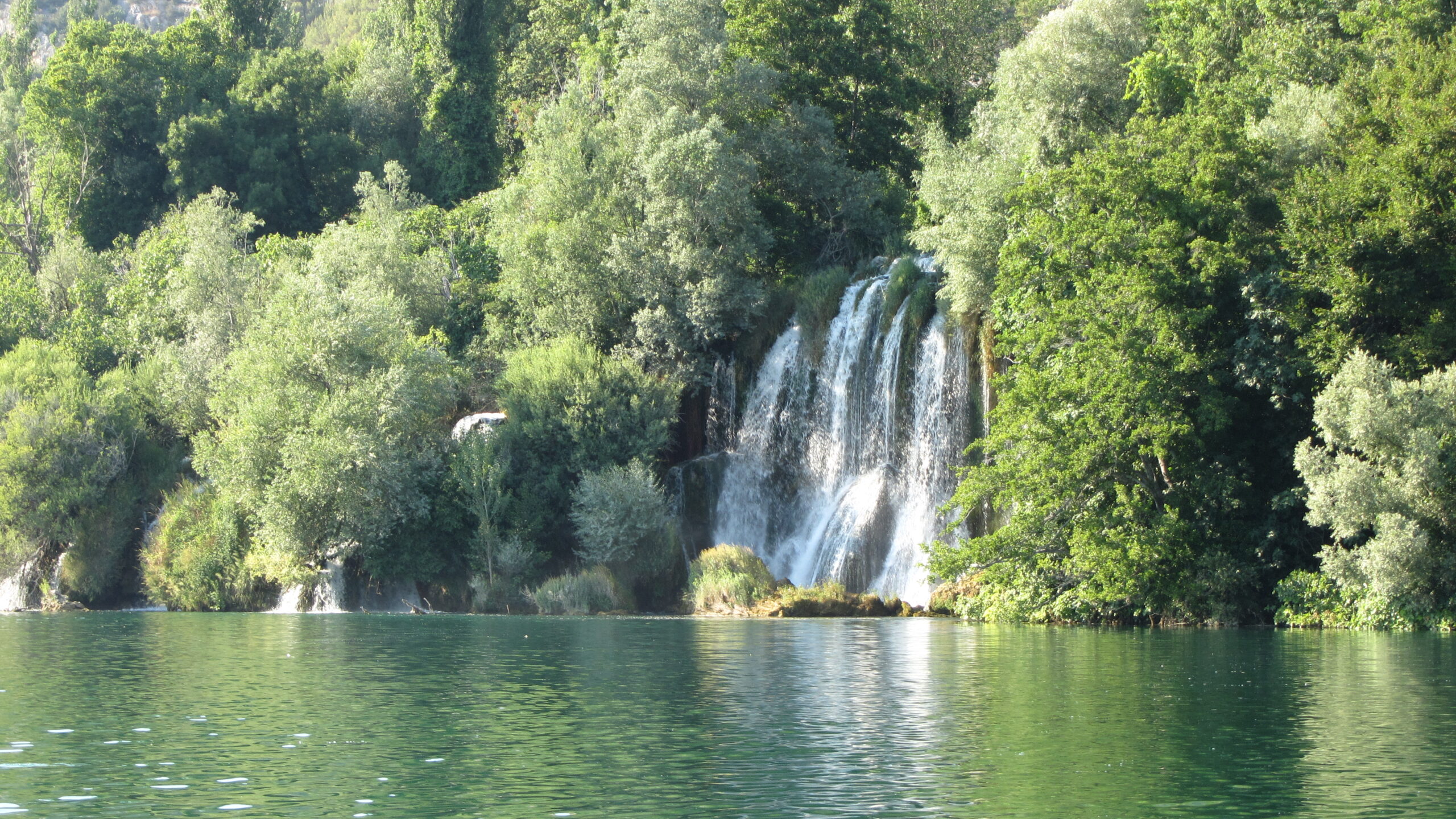 Wide view of the Krka river spilling over travertine waterfall terraces