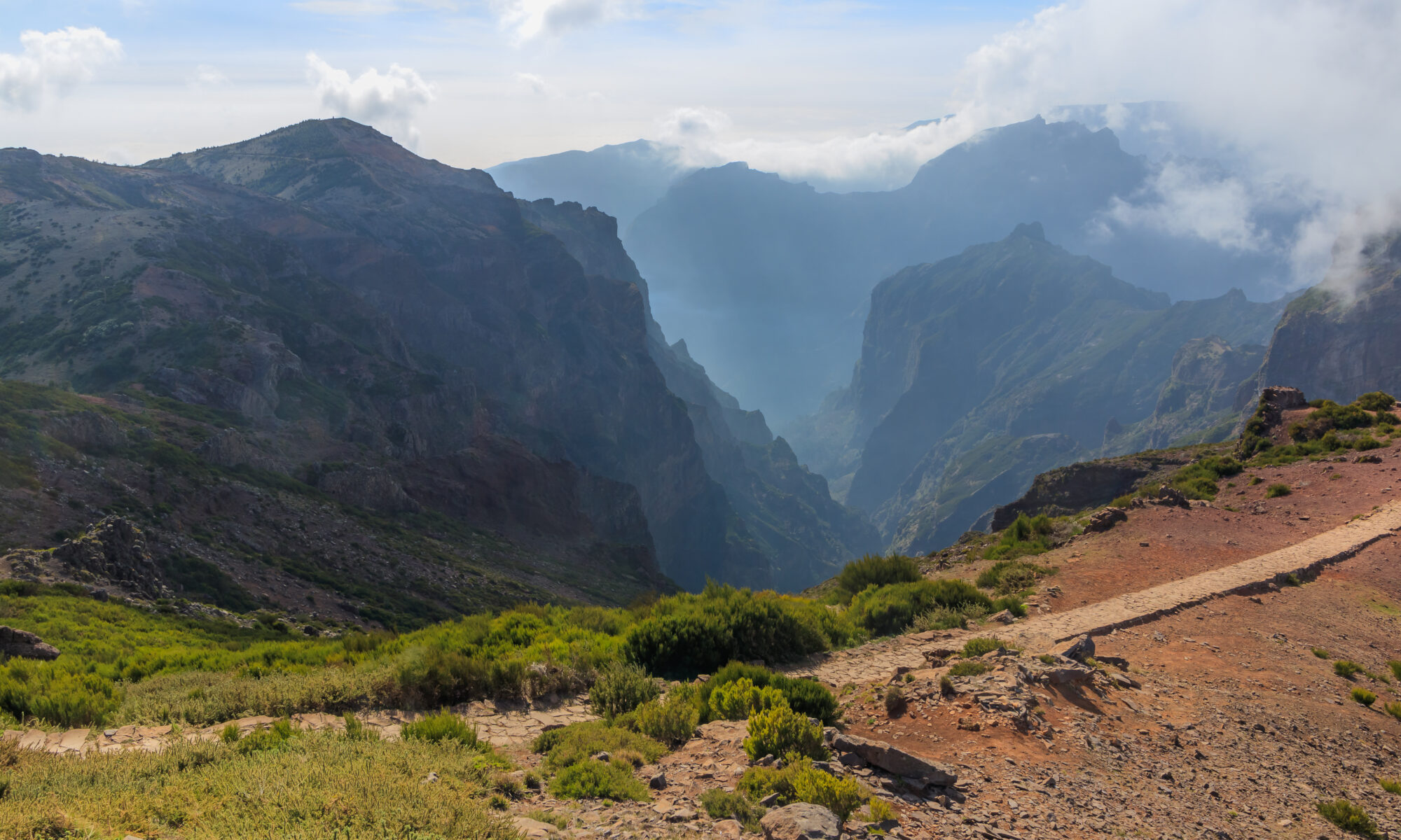 Jagged volcanic peaks rising above a sea of clouds at Pico do Arieiro in Madeira, Portugal