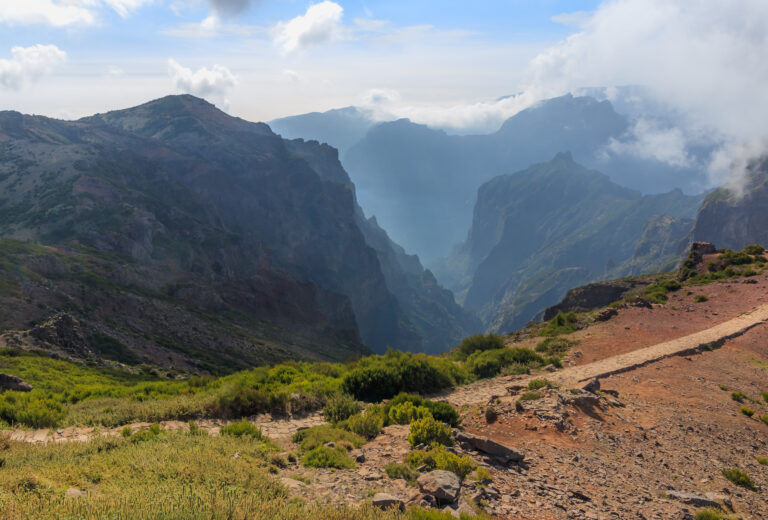 Jagged volcanic peaks rising above a sea of clouds at Pico do Arieiro in Madeira, Portugal