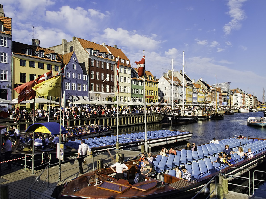 Colorful townhouses and boats along Nyhavn harbor in Copenhagen Denmark