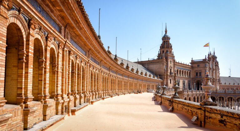 The grand curved facade and canal of Plaza de Espana in Seville Spain