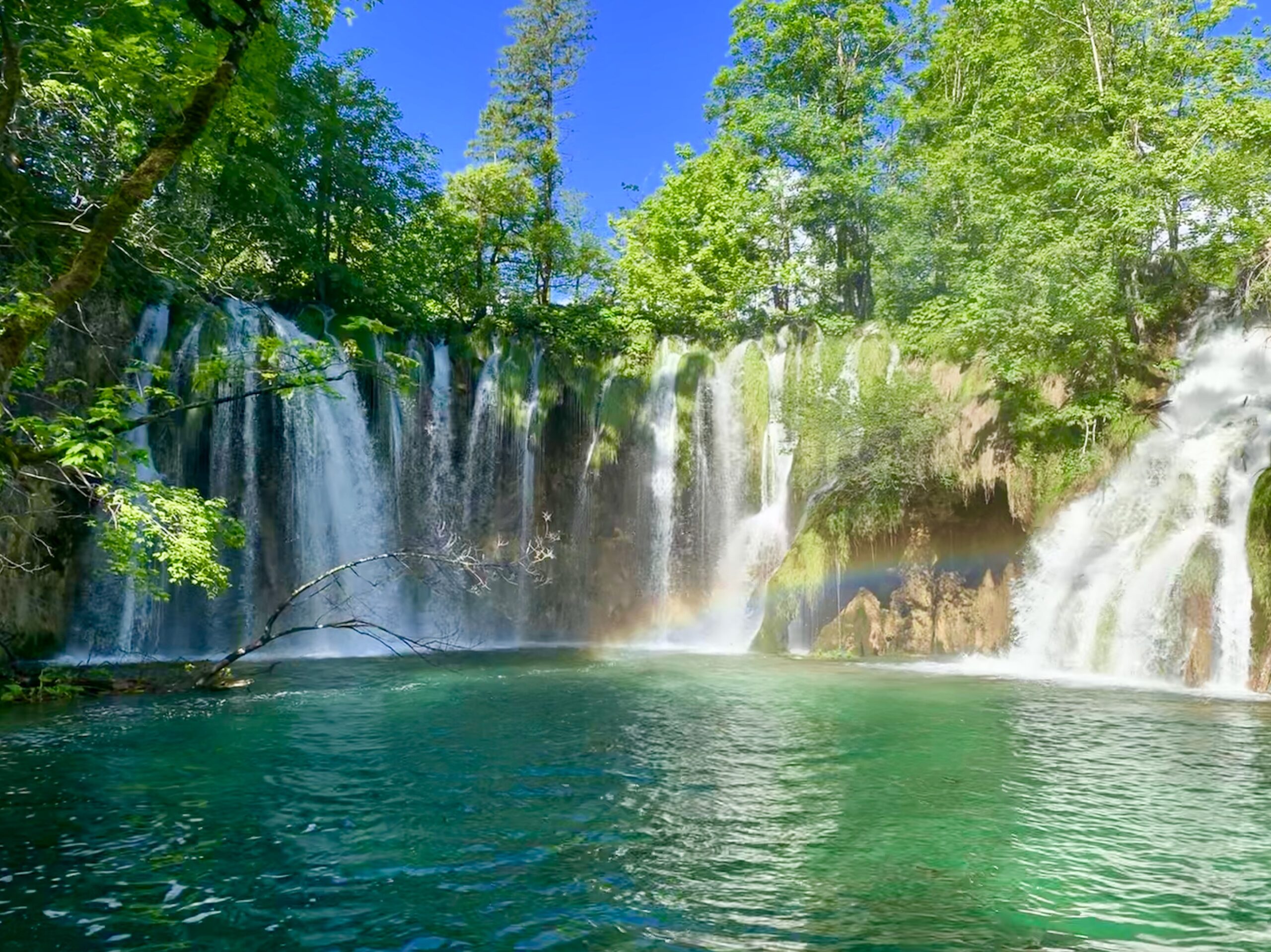 A rainbow over the waterfalls and turquoise pools of Plitvice Lakes National Park