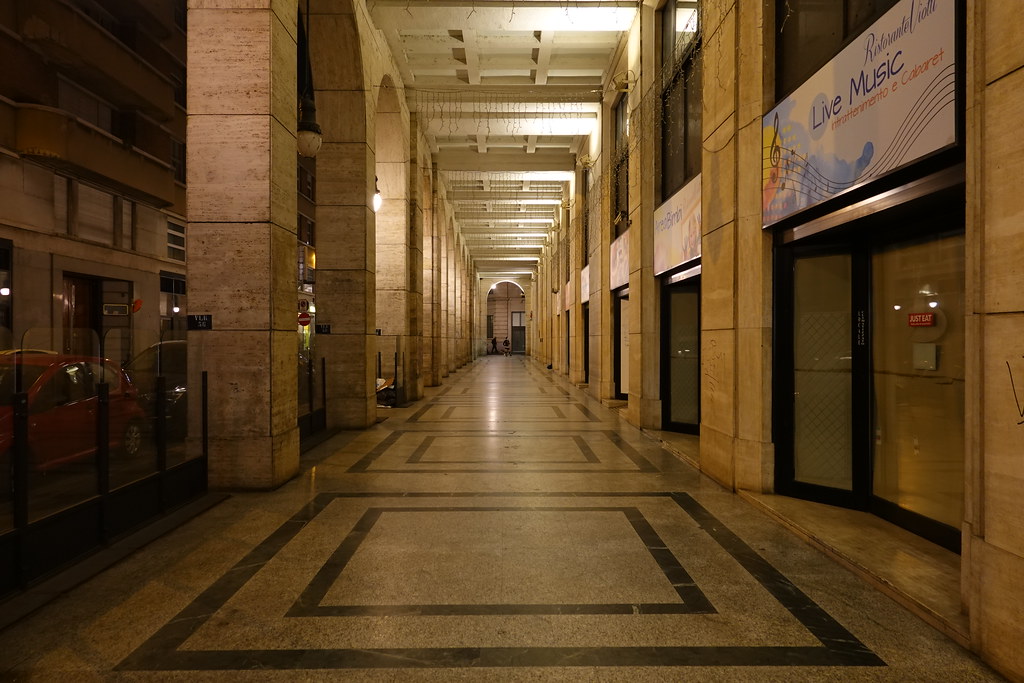 Turin covered arcades glowing in the evening along Via Roma