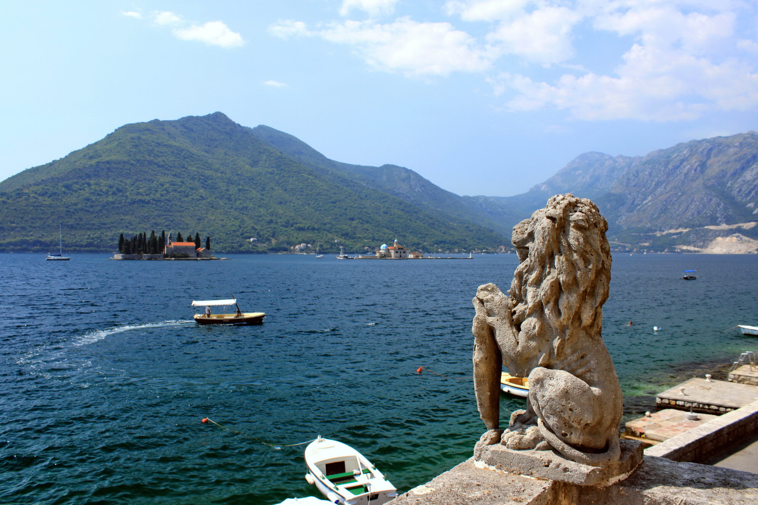 A carved stone lion overlooking the Bay of Kotor and its islands from Perast in Montenegro
