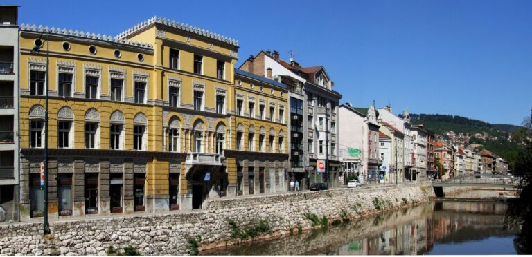 The Miljacka river running through central Sarajevo past historic buildings and green hillsides