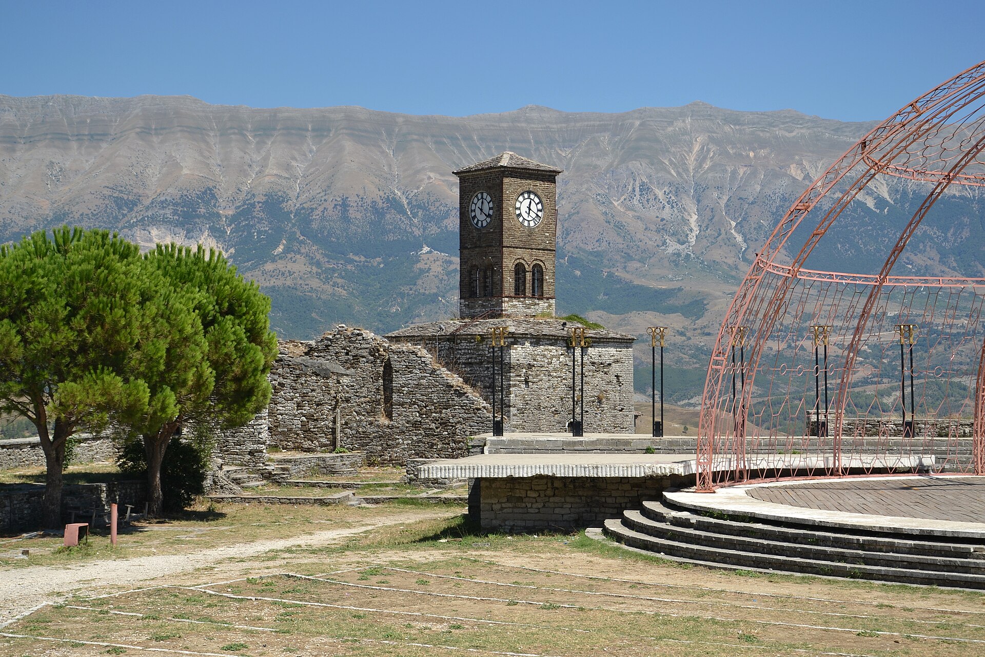 Clock tower on the walls of Gjirokaster Castle with the Drino valley mountains behind