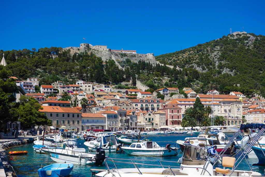 Sailboats and fishing boats in the bright blue harbor of Hvar town, Croatia
