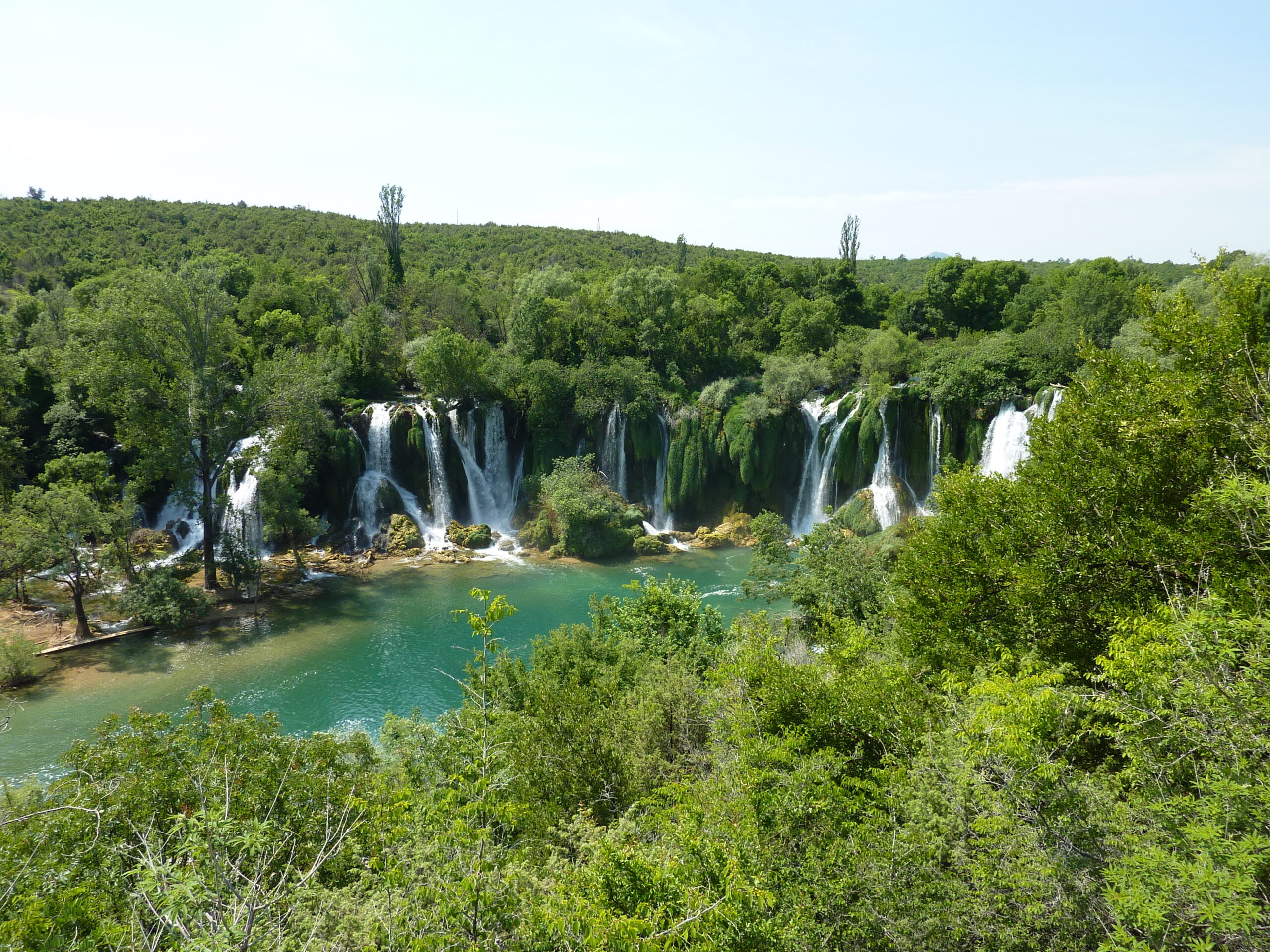 The horseshoe of Kravice Waterfalls dropping into a green pool south of Mostar